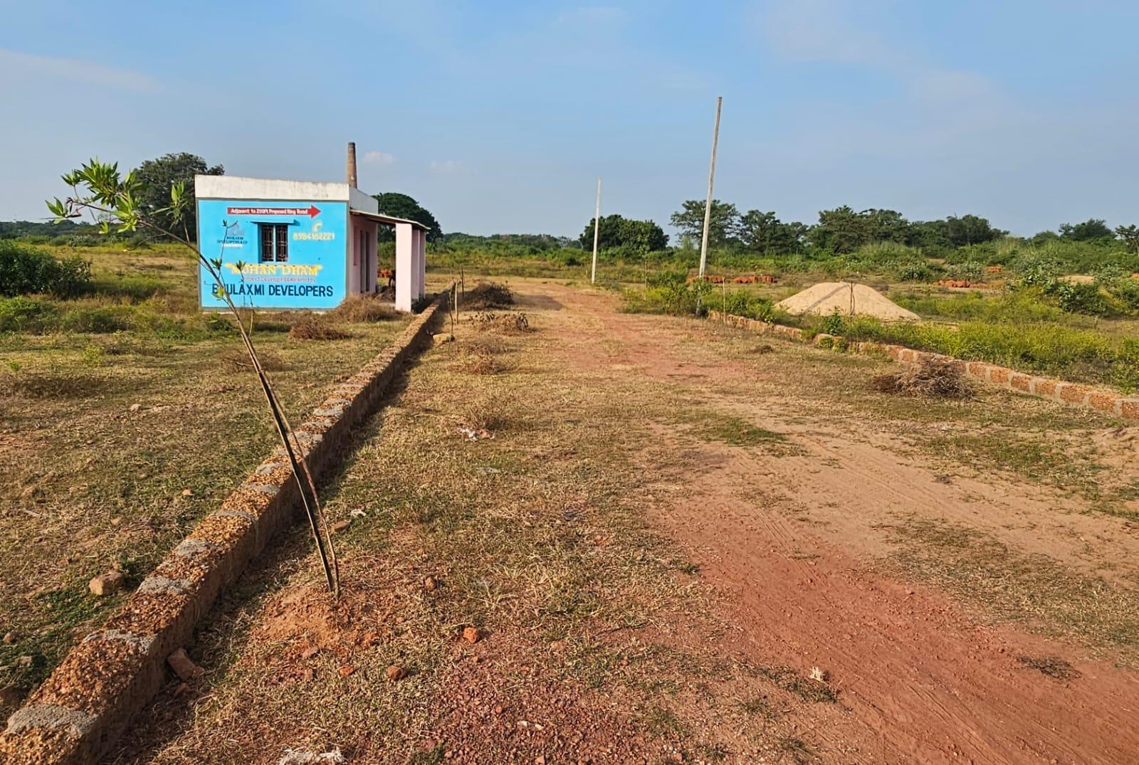 Wide view of Mohan Dham site with project office, signage and master layout
